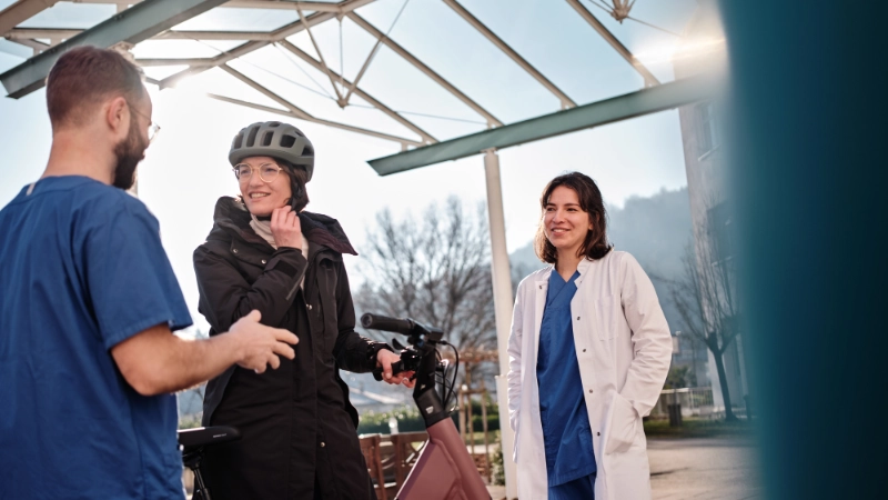 Zwei Pfleger:innen im Gespräch mit einer JobRadlerin