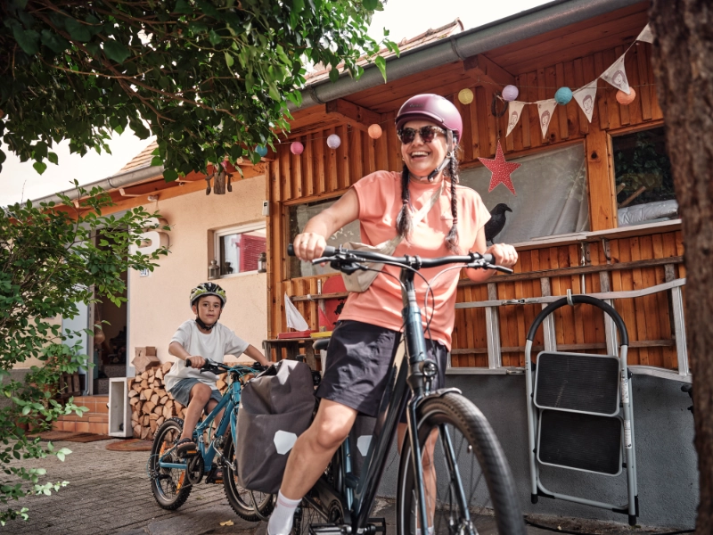 Frau und Kind fahren mit Follow-Me Kupplung zuhause los Frau und Kind fahren mit Follow-Me Kupplung zuhause los